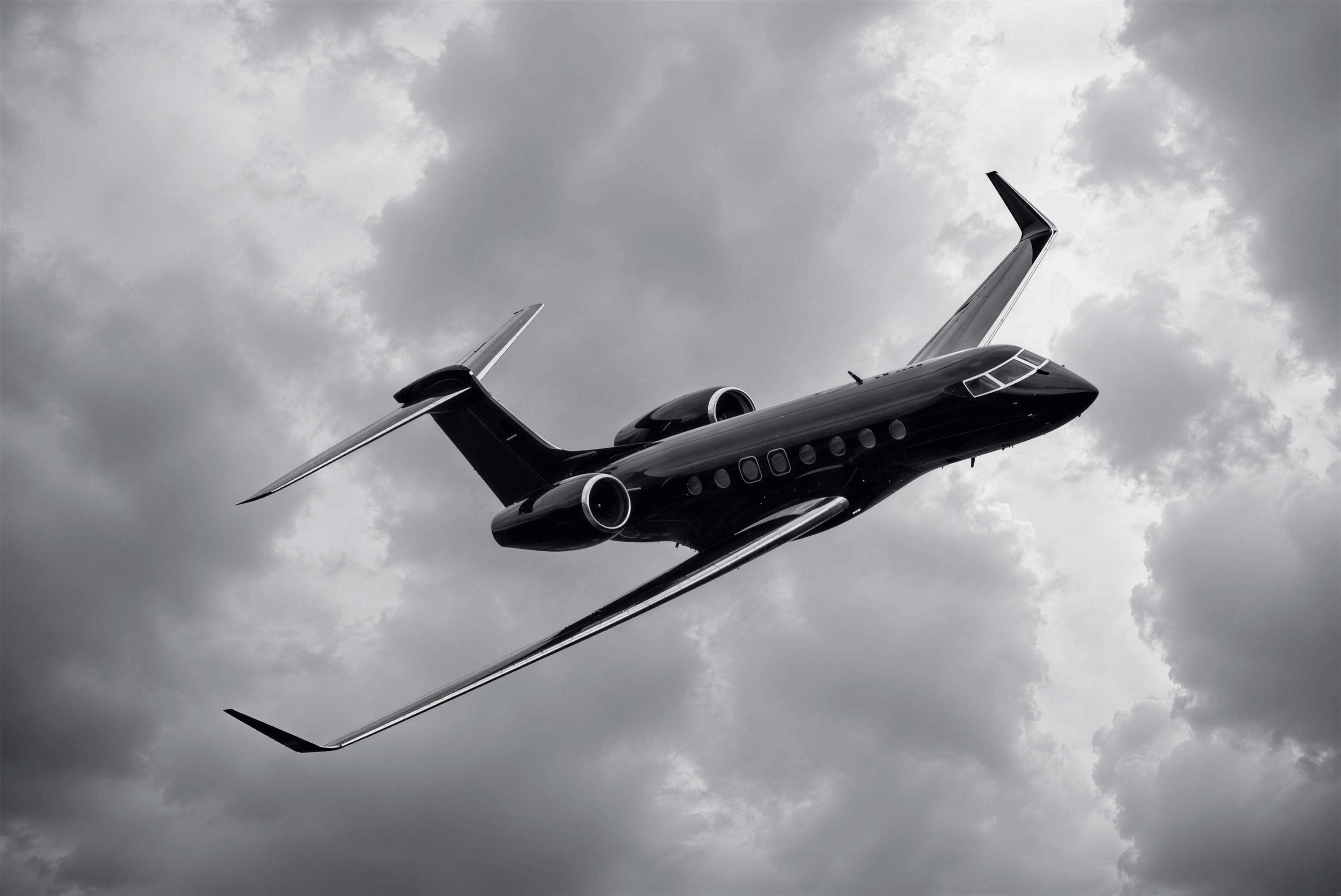 Private jet flying through dramatic clouded sky