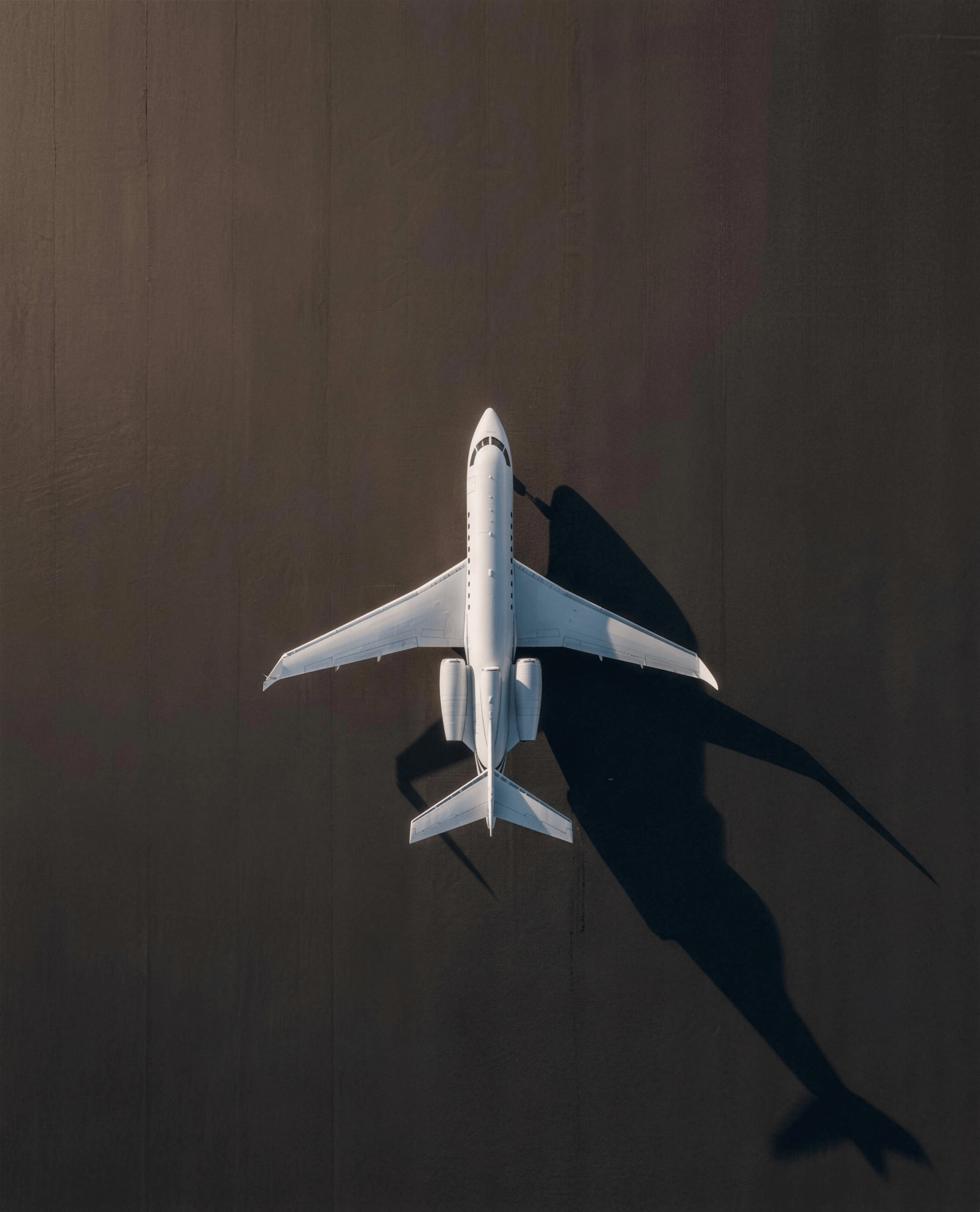 Private jet from above with shadow indicating return route